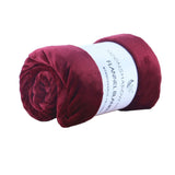 Rolled wine red flannel blanket, soft coral fleece air-conditioning cover for cozy nap or bedding.