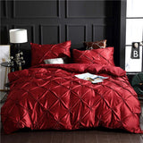 Luxurious red washed silk three-piece bedding set with decorative stitching, featuring a duvet cover and two pillowcases.