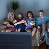Friends enjoying a movie night on a large fluffy bean bag chair, sharing snacks and laughter in a cozy living room.