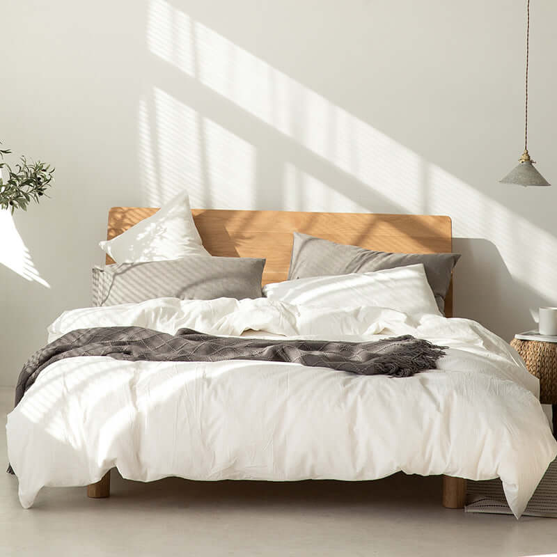 Japanese style Muji-style bed with pure color lattice duvet cover and white bedding in modern bedroom.