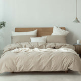Japanese style Muji-style bedding set with neutral tones, featuring duvet cover and pillows on a wooden bed.