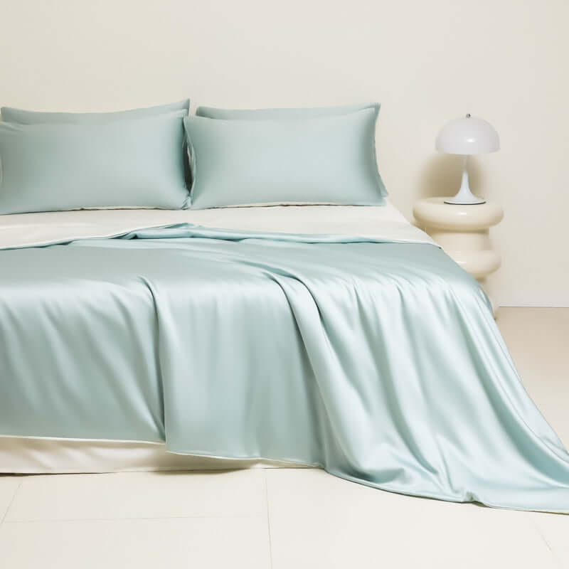 Washed Ice Silk Solid Color Silky Sleep Naked Bed Sheet Quilt Cover Fitted Sheet in light blue color on a bed.