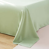 Soft green cotton and linen summer blanket draping elegantly over a bed.