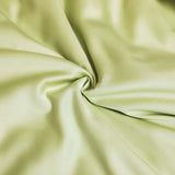 Close-up of soft, washed ice silk fabric in a light green color, perfect for sleeping and bedding.