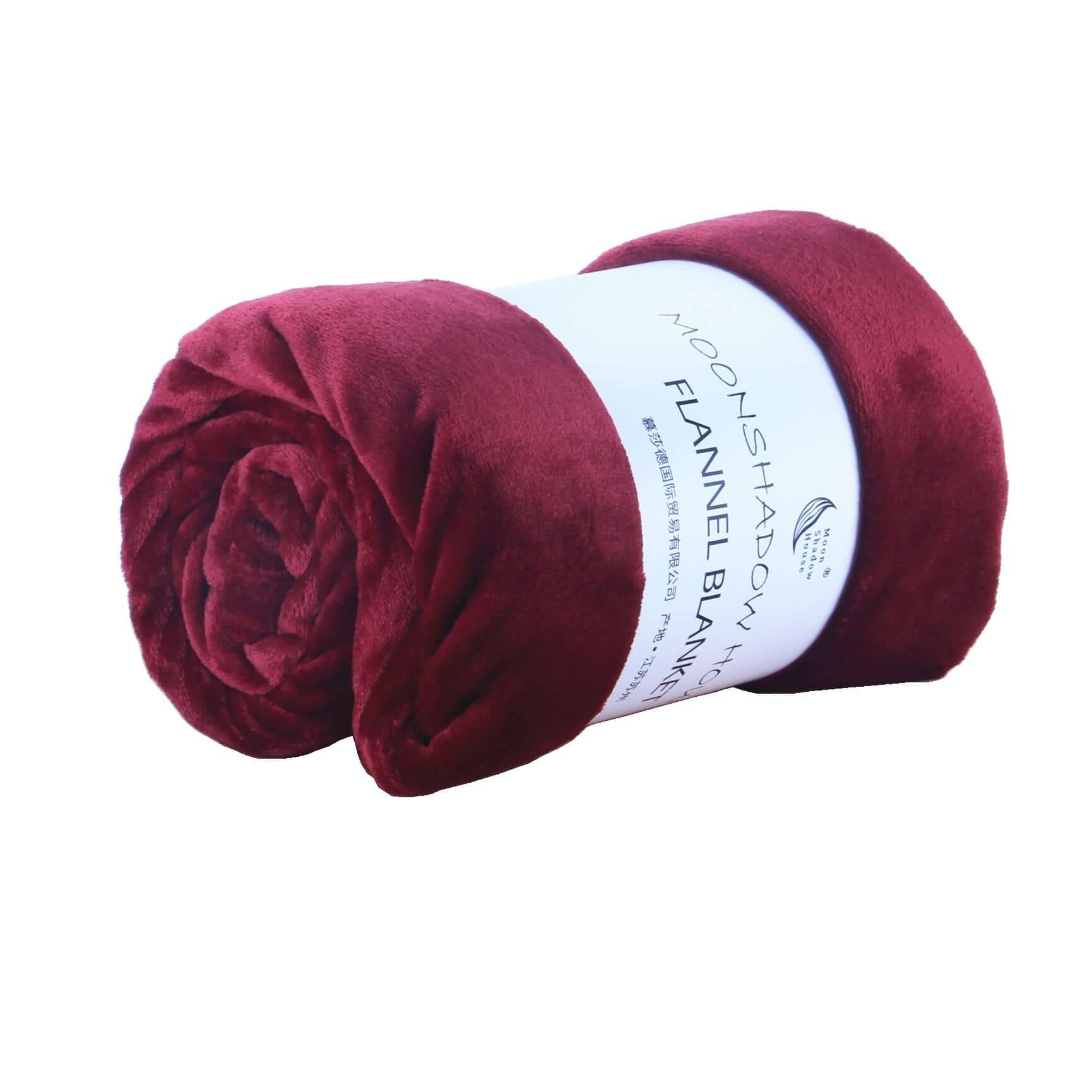 Rolled wine red flannel blanket, soft coral fleece air-conditioning cover for cozy nap or bedding.
