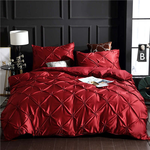 Luxurious red washed silk three-piece bedding set with decorative stitching, featuring a duvet cover and two pillowcases.