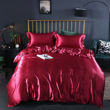 Summer Simple Pure Color Ice Silk Bed Linen Quilt Cover Bedding in luxurious red with matching pillows on a stylish bed.