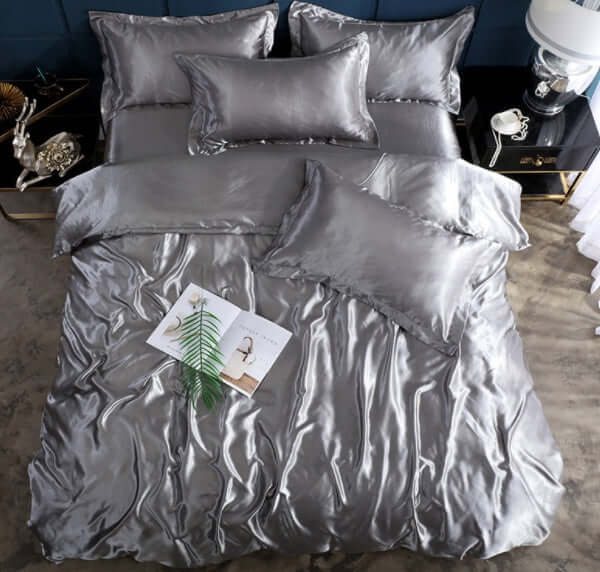 Shiny silver bed sheet quilt cover set with pillows, perfect for a cool and elegant sleeping experience.
