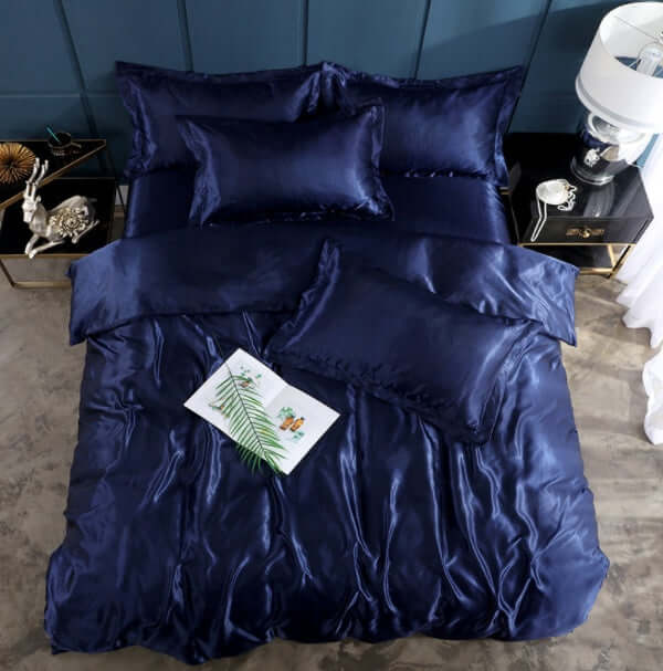 Navy blue silk bed sheet quilt cover set with pillows, ideal for a cool and elegant sleeping experience.