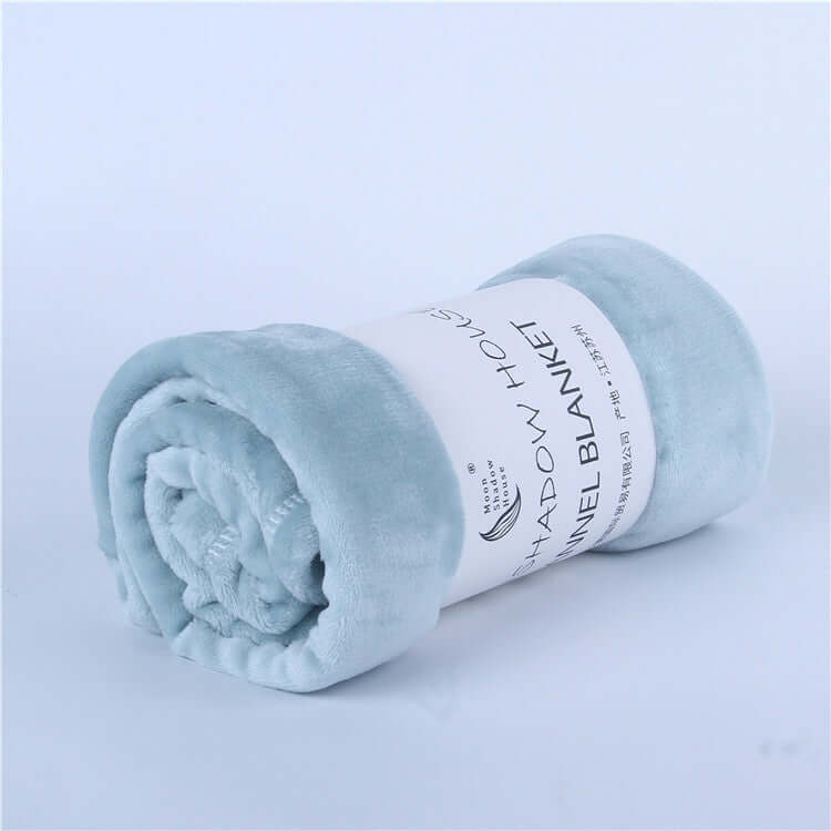 Soft flannel blanket rolled up in light blue, perfect for cozy warmth and air-conditioning use.