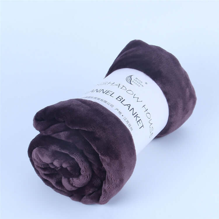 Rolled flannel blanket in rich purple color with label featuring 'Flannel Blanket' design.