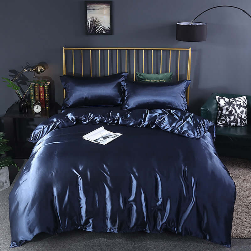 Navy blue ice silk quilt cover bedding set with pillows on a stylish bed frame, perfect for summer decor.